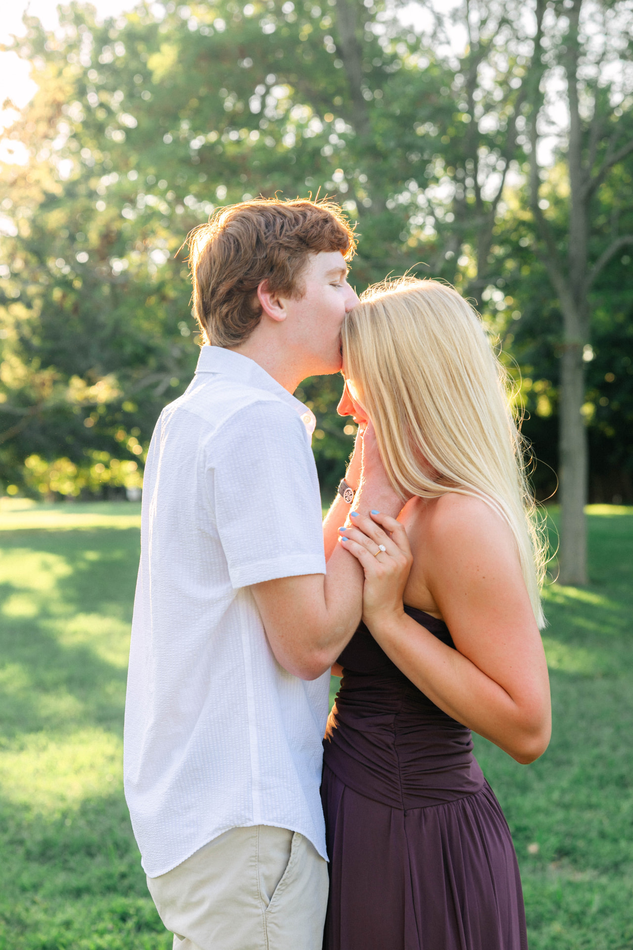 Colin kissing Samantha on the forehead in the summer sunlight